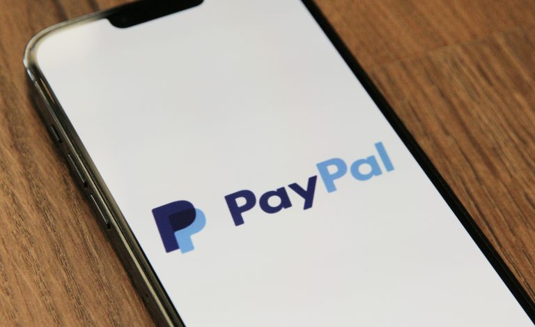 PayPal-logo älypuhelimen näytöllä puupinnalla